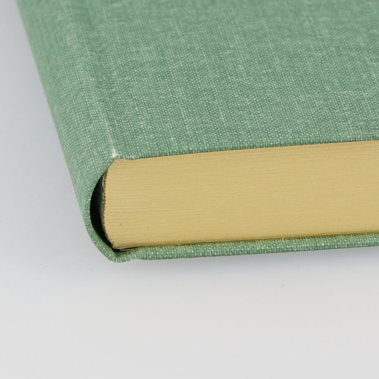 表紙にはやさしい手触りの布クロスを使用。ゴールドまたはシルバーの小口が光る、書籍のような丸背のハードカバーです。